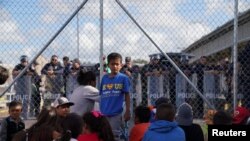Migrants, returned to Mexico to await their U.S. asylum hearings, block the Puerta Mexico international border crossing bridge to demand a faster asylum process, in Matamoros, Mexico, Oct. 10, 2019. 