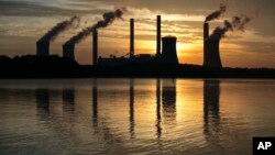 FILE - The coal-fired Plant Scherer, one of the nation's top carbon dioxide emitters, stands in the distance in Juliette, Georgia, June 3, 2017. 