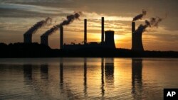 FILE - The coal-fired Plant Scherer, one of the nation's top carbon dioxide emitters, stands in the distance in Juliette, Ga., June 3, 2017. The Trump administration intends to roll back the centerpiece of former President Barack Obama’s efforts to slow global warming, seeking to ease restrictions on greenhouse gas emissions from coal-fired power plants. Young activists are suing the government for ignoring climate change.