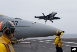 An F/A-18 Hornet approaches to the nuclear-powered aircraft carrier the USS John C. Stennis during joint military exercise between the United States, Japan and India off the coast 180 miles east of Japan's southernmost island of Okinawa, June 15, 2016.