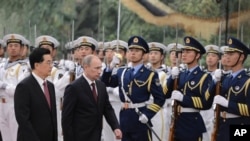 Presiden Rusia Vladimir Putin (dua dari kiri) berdampingan dengan Presiden Tiongkok Hu Jintao (kiri) disambut dengan upacara penghormatan dalam pertemuan puncak regional 'Shanghai Cooperation Organizatio (SCO)' di Beijing (6/5).