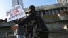 FILE - Police officers restrain a protester during a rally of journalists against a new media bill, in front of the Parliament building in Baku, Azerbaijan, on Dec. 28, 2021. 