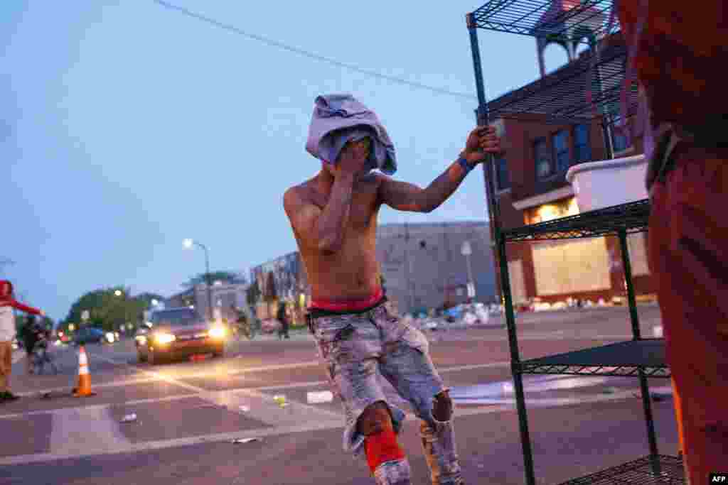 A man reacts during clashes at a protest outside the Third Police Precinct on May 28, 2020 in Minneapolis, Minnesota, over the death of George Floyd, an unarmed black man, died after a police officer kneeled on his neck for several minutes. -…