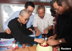 FILE - Liu Xia, wife of deceased Chinese Nobel Peace Prize-winning dissident Liu Xiaobo and other relatives attend his sea burial off the coast of Dalian, China, in this photo released by Shenyang Municipal Information Office July 15, 2017.
