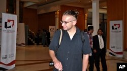 In this Sunday, Jun. 30, 2013, Luke Somers, 33, an American photojournalist who was kidnapped over a year ago by al-Qaida speaks to a man during the National Dialogue Conference in Sanaa, Yemen. 