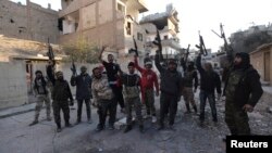 Members of the Jund Allah Brigades, part of the Free Syrian Army, hold their weapons as they pose for a photograph in Deir al-Zor, eastern Syria February 18, 2014. 