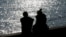 FILE - A couple is silhouetted at the harbor of Livorno, central Italy, Feb. 14, 2017.