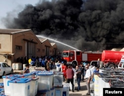 FILE - rises from a storage site in Baghdad, housing ballot boxes from Iraq's May parliamentary election, June 10, 2018.