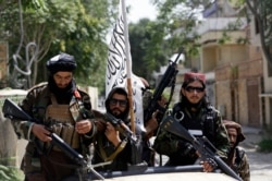 Taliban fighters display their flag as they patrol in Kabul, Afghanistan, Aug. 19, 2021.