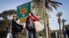 FILE - Shoppers walk with their purchases near the U.S.-Mexico border in San Ysidro, California, on Nov. 26, 2024.