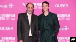 Director Luca Guadagnino, left, and actor Drew Starkey pose for photographers upon arrival at the premiere for the film "Queer" during the London Film Festival, Oct. 17, 2024, in London. (Scott A. Garfitt/Invision/AP)