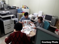 North Korean defectors, working for FreeNK newspaper in South Korea, wrap editions of paper in plastic, ready for the air drop. (Photo: FreeNK)