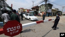 Local police officers stand guard at a blocked street near Phnom Penh International airport in Phnom Penh, Cambodia, April 15, 2021 as the country’s capital will be locked down for two weeks from following a sharp rise in COVID-19 cases.