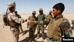 FILE - A U.S. Marine shakes hands with Afghan National Army (ANA) soldiers during a training exercise in Helmand province, Afghanistan, July 5, 2017. Helmand was the scene of an errant U.S. drone strike Friday.
