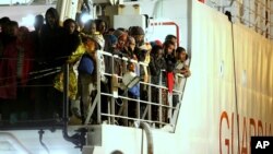 Rescued migrants wait to disembark from an Italian Coast Guard ship in the harbor of Palermo, Sicily, southern Italy, April 14, 2015.