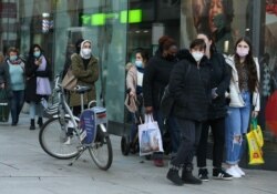 People queue in front of a shop, as the coronavirus disease outbreak continues, in Frankfurt, Germany, Dec. 14, 2020.