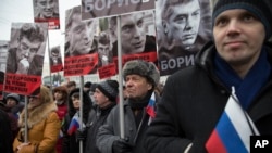People carry portraits of opposition leader Boris Nemtsov, who was gunned down on Friday near the Kremlin, with words reading "He fought for a free of Russia, He fought for our future!" in Moscow, Russia, March 1, 2015. 