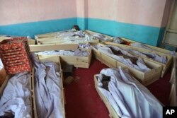 FILE - Bodies of civilians and security forces are placed at a hospital in Ghazni province, west of Kabul, Afghanistan, Aug. 12, 2018.