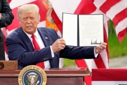President Donald Trump holds a signed memorandum to expand the offshore drilling moratorium to the coasts of Florida, Georgia and South Carolina after speaking at the Jupiter Inlet Lighthouse and Museum, Sept. 8, 2020, in Jupiter, Florida.