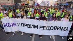 Women hold a banner reading "Women in front rows" during a march on International Women's Day in Belgrade, Serbia, on March 8, 2025.
