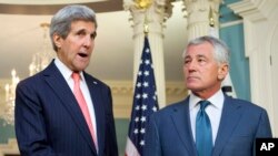 FILE - Secretary of State John Kerry, left, joined by Defense Secretary Chuck Hagel, speaks to media at the State Department in Washington, Oct. 24, 2014.