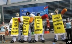In Busan, members from Save The Children and World Vision stage a demonstration urging donor countries to fulfill their aid commitments.