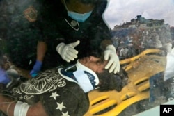 A U.S. doctor attends to Pemba Tamang inside an ambulance after being rescued by Nepalese policemen and U.S. rescue workers from a building that collapsed five days ago in Kathmandu, Nepal, April 30, 2015.