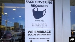 Bảng yêu cầu khách hàng đeo khẩu trang bee6n trong một cửa hàng ở Dallas, bang Texas, ngày 2 tháng 3, 2021.