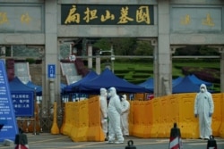 People wearing protective suits are seen in Biandanshan cemetery in Wuhan, Hubei province, the epicenter of China's coronavirus disease outbreak, April 1, 2020.
