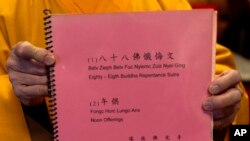 Monk Dauv Singx Si holds a collection of sutras at the Iu Mien Buddha Light Temple on April 30, 2024, in Gresham, Ore. There is a sizeable Iu Mien community in Portland and its suburbs, with a Buddhist temple, Baptist church, active social group, and businesses and restaurants.