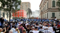 Police block rotesters during the demolition of the national theater building in Tirana, Albania, May 17, 2020.