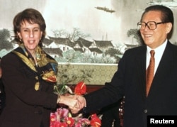 资料照片：美国贸易代表巴尔舍夫斯基与中国领导人江泽民在北京举行的WTO签字仪式上握手。(1999年11月15日)