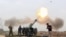 FILE - Iraqi security forces fire at Islamic State militants positions from villages south of the Islamic State group-held city of Mosul, Iraq, March 26, 2016.