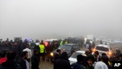 En esta fotografía proporcionada por la agencia de noticias Moj, se ven equipos de rescate y personas cerca del lugar del incidente del helicóptero que transportaba al presidente iraní Ebrahim Raisi en Varzaghan, en el noroeste de Irán, el domingo 19 de mayo de 2024.