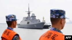 FILE - This photo taken on Oct. 21, 2018, shows Chinese sailors watching as a Singapore navy ship arrives at a military port in Zhanjiang, in China's southern Guangdong province.