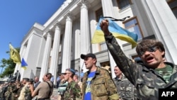 Maidan self-defense activists shout slogans in front of the Ukrainian parliament building in Kyiv on July 1, 2014.