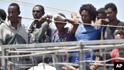 Migrants wait to be disembarked from the Irish Navy ship P31 L.E. Eithne at the Catania harbor, Italy, June 16, 2015. 