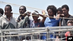 FILE - Migrants wait to be disembarked from the Irish Navy ship P31 L.E. Eithne at the Catania harbor, Italy, June 16, 2015. 
