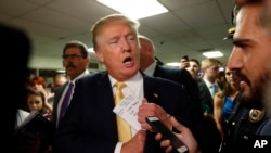 A reference to New England Patriots quarterback Tom Brady is seen on the notes of Republican presidential candidate Donald Trump as he tucks his papers into his jacket as he arrives at a town hall event, Sept. 17, 2015, in Rochester, N.H.