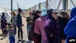 FILE - A group of women, reportedly the wives of suspected Islamic State (IS) fighters, are pictured on March 28, 2021 at Camp al-Roj,