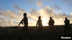 FILE - Somali army soldiers are seen near Barawe, Somalia, Oct. 4, 2014.