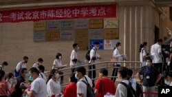 FILE - Students line up to enter a school for the first day of China's national college entrance examinations, in Beijing on June 7, 2022. After the pandemic, young Chinese are again looking to study abroad.