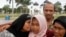 Jamaliah (L) kisses her daughter Raudhatul Jannah, 14, as the girl's father Septi Rangkuti and grandmother Sarwani look on following prayers at Baiturrahman mosque in Banda Aceh, Aug. 8, 2014. 