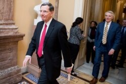 FILE - Sen. John Barrasso, left, walks to a meeting on Capitol Hill, Feb. 11, 2019, in Washington. In the background is Sen. Rob Portman.