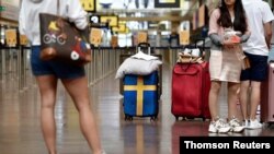 Passengers prepare to check in at Arlanda airport for the first chartered TUI flight to Rhodes in Greece since the outbreak of the coronavirus disease (COVID-19), in Stockholm