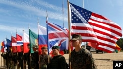 FILE - Soldiers from NATO countries attend a opening ceremony of military exercise Saber Strike 2015, at the Gaiziunu Training Range in Pabrade some 60km (38 miles) north of the capital Vilnius, Lithuania, June 8, 2015.