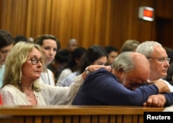FILE - Barry Steenkamp, father of Reeva Steenkamp, is consoled by his wife June Steenkamp during the sentencing hearing of Olympic and Paralympic track star Oscar Pistorius at the North Gauteng High Court in Pretoria, Oct. 15, 2014.