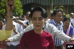 FILE - Myanmar opposition leader and head of the National League for Democracy (NLD) Aung San Suu Kyi (C) visits a polling station in Kawhmu township, Yangon, Nov. 8, 2015.