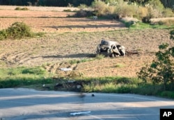 FILE - The wreckage of the car of investigative journalist Daphne Caruana Galizia is seen on a roadside in the town of Mosta, Malta, Oct. 16, 2017.