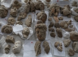 FILE - Pieces of statues damaged by the Taliban are laid out on a table for restoration at the national museum in Kabul, Afghanistan, Oct. 13, 2019.